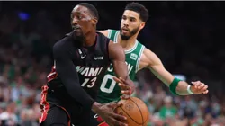 Bam Adebayo #13 of the Miami Heat controls the ball ahead of Jayson Tatum #0 of the Boston Celtics