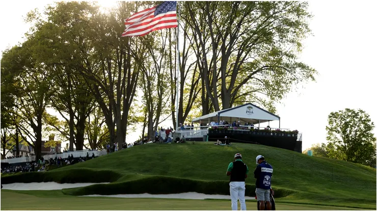Hideki Matsuyama of Japan and caddie Shota Hayafuji wait on a fairway during the first round of the 2023 PGA Championship