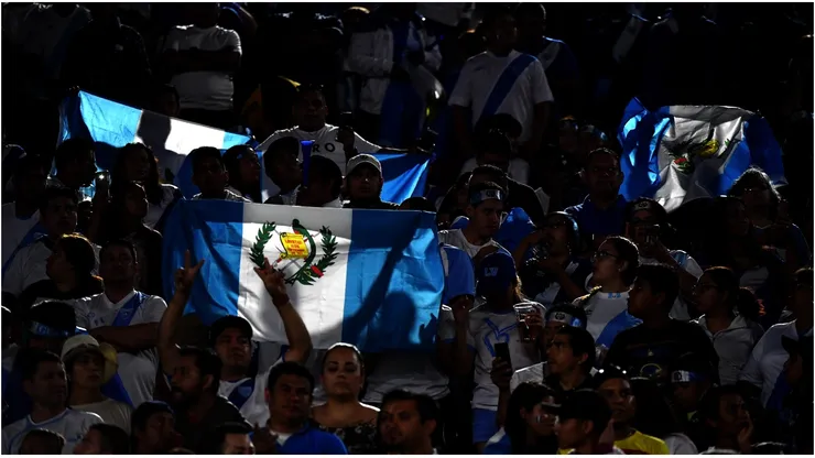 Fans hold up flags before