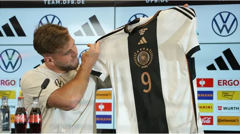 Niclas Fuellkrug holds up a team shirt