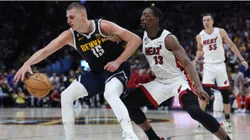 Nikola Jokic #15 of the Denver Nuggets dribbles against Bam Adebayo #13 of the Miami Heat