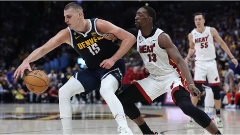Nikola Jokic #15 of the Denver Nuggets dribbles against Bam Adebayo #13 of the Miami Heat
