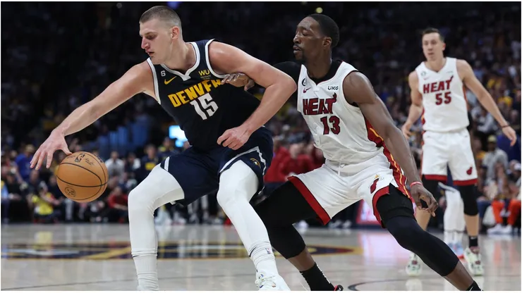 Nikola Jokic #15 of the Denver Nuggets dribbles against Bam Adebayo #13 of the Miami Heat