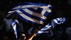 A Greece fan waves flags