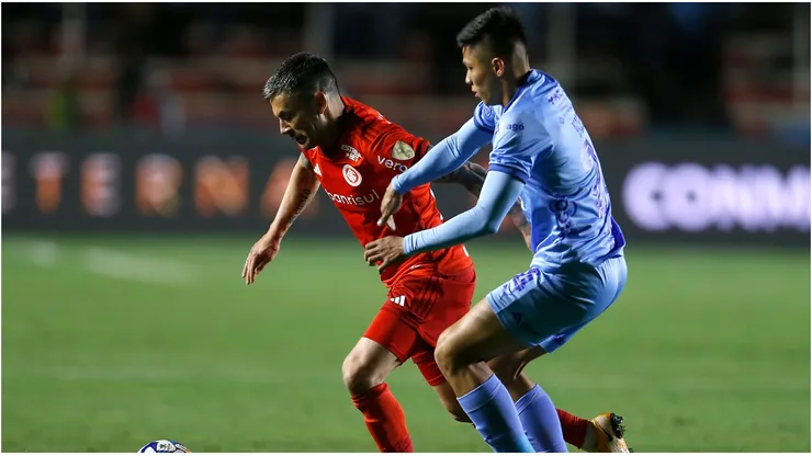 Charles Aránguiz of Internacional battles for possession with Javier Uzeda of Bolivar