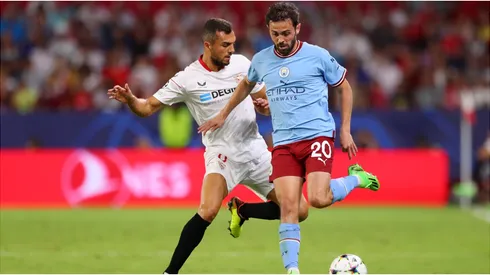 Bernardo Silva of Manchester City is challenged by Joan Jordan of Sevilla FC