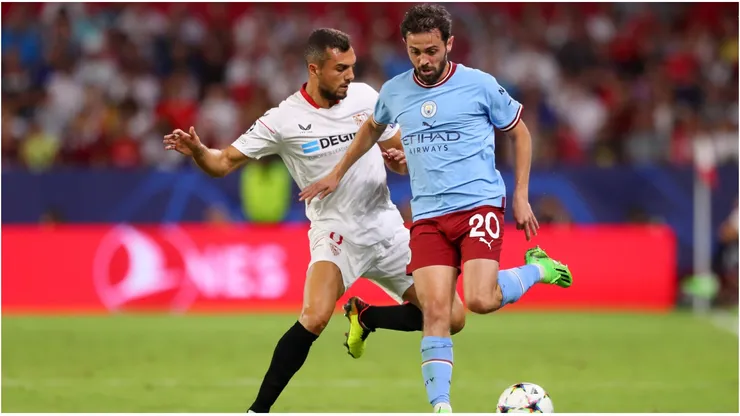 Bernardo Silva of Manchester City is challenged by Joan Jordan of Sevilla FC