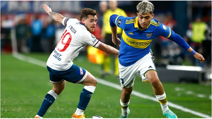 Alfonso Trezza of Nacional competes for the ball with Exequiel Zeballos of Boca Juniors