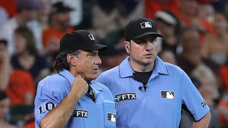 Umpires Phil Cuzzi and Dan Bellino await the review of a play