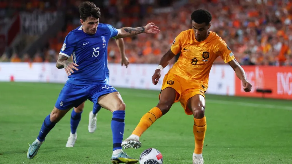 Cody Gakpo of Netherlands controls the ball whilst under pressure from Lazaros Rota of Greece-Dean Mouhtaropoulos/Getty Images