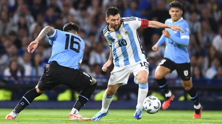 Lionel Messi trying to dribble past Mathias Olivera