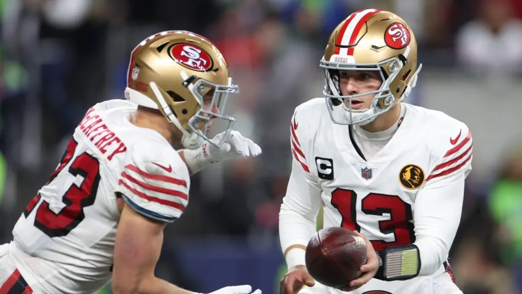 Brock Purdy #13 of the San Francisco 49ers hands off the ball to Christian McCaffrey #23 of the San Francisco 49ers during the second quarter against the Seattle Seahawks at Lumen Field on November 23, 2023 in Seattle, Washington.