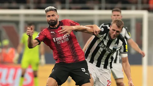 Olivier Giroud of AC Milan competes for the ball with Dan Burn of Newcastle United FC during the UEFA Champions League match between AC Milan and Newcastle United FC at Stadio Giuseppe Meazza on September 19, 2023 in Milan, Italy.