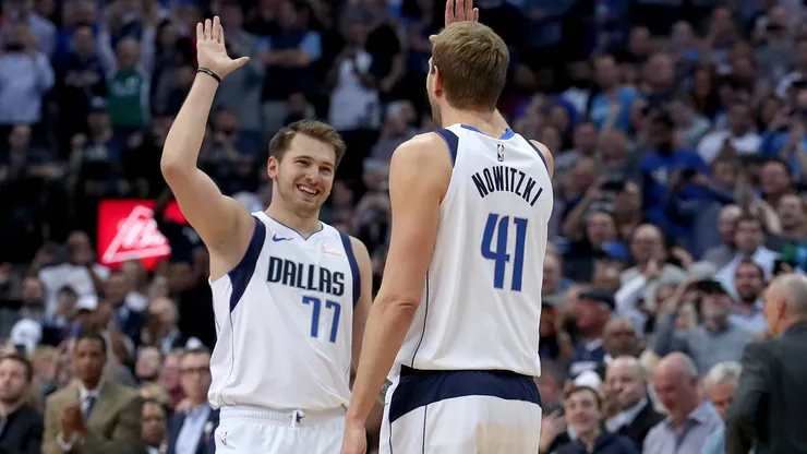 Luka Doncic and Dirk Nowitki celebrating during a Dallas Mavericks game.