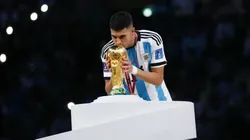 Exequiel Palacios kissing the World Cup trophy.