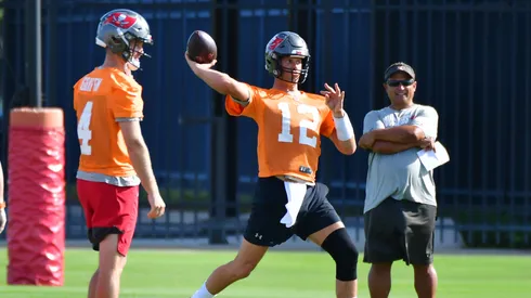 Ryan Griffin #4 (L) and quarterback coach Clyde Christensen (R) look on as Tom Brady #12 of the Tampa Bay Buccaneers throws a pass during the Buccaneers Mini-Camp at AdventHealth Training Center on June 08, 2021 in Tampa, Florida.