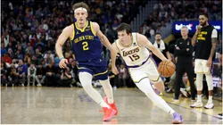 Austin Reaves #15 of the Los Angeles Lakers is guarded by Brandin Podziemski #2 of the Golden State Warriors