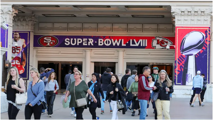 Visitors walk in front of an entrance to Caesars Palace with Super Bowl LVIII signage displayed