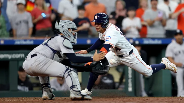 Mauricio Dubon #14 of the Houston Astros is out at the plate in the ninth inning against Jose Trevino #39 of the New York Yankees on Opening Day at Minute Maid Park on March 28, 2024 in Houston, Texas.