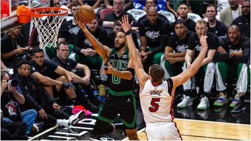The Boston Celtics Jayson Tatum (0) lays up the ball while defended by the Miami Heat's Nikola Jovic
