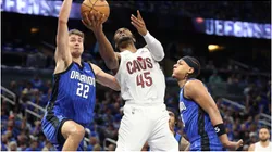 Cleveland Cavaliers' Donovan Mitchell scores between the Orlando Magic's Franz Wagner and Paolo Banchero