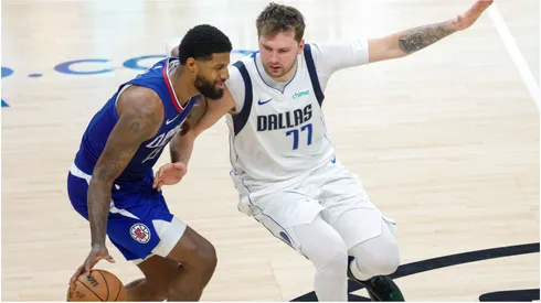 Los Angeles Clippers Paul George (L) drives against Dallas Mavericks Luka Doncic (R)