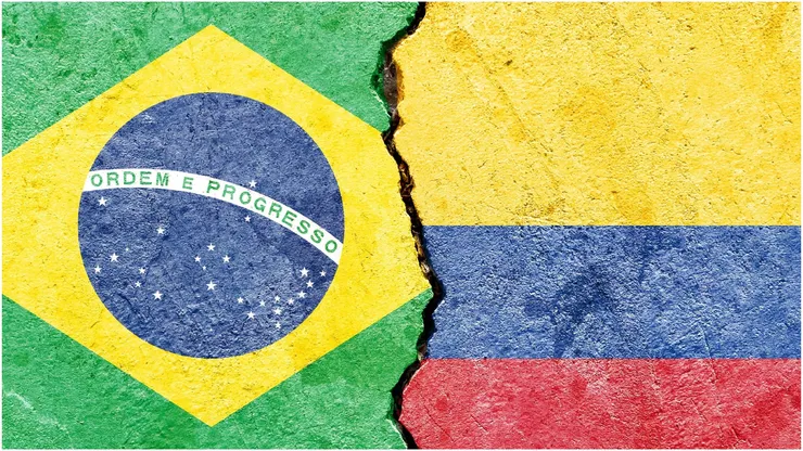 The Brazil and Colombia flags on a cracked wall