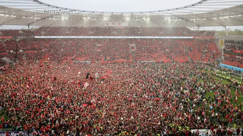 Fans of Bayer 04 Leverkusen invade the pitch after their team's victory and winning the Bundesliga title for the first time in their history