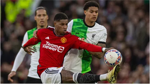 Manchester United's Marcus Rashford (L) is challenged by Liverpool's Jarell Quansah