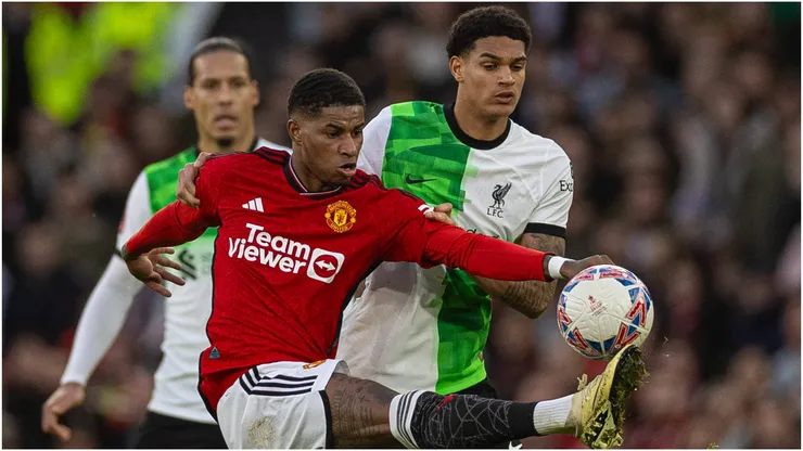 Manchester United's Marcus Rashford (L) is challenged by Liverpool's Jarell Quansah
