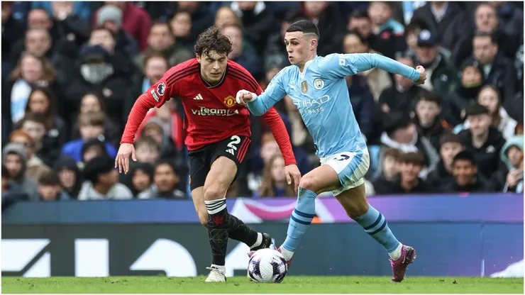 Phil Foden of Manchester City breaks with the ball tracked by Victor Lindelöf of Manchester United