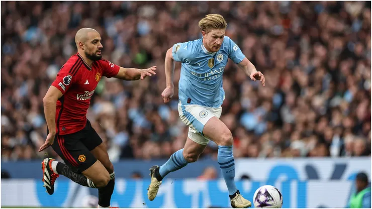 Kevin De Bruyne of Manchester City breaks with the ball tracked by Sofyan Amrabat of Manchester United