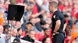 Craig Pawson checks the Video Assistant Referee during the Premier League match between Liverpool and Everton
