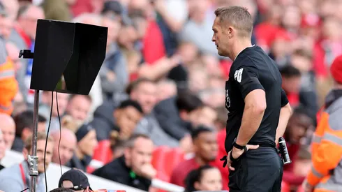 Craig Pawson checks the Video Assistant Referee during the Premier League match between Liverpool and Everton