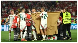 Players of Hungary hold up blankets as they assist medical staff by covering Barnabas Varga of Hungary as he receives medical treatment following a collision with Angus Gunn of Scotland during the UEFA EURO 2024 group stage match.