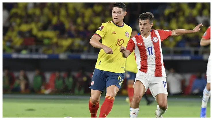Andres Cubas of Paraguay and James Rodriguez of Colombia fight for the ball during a match