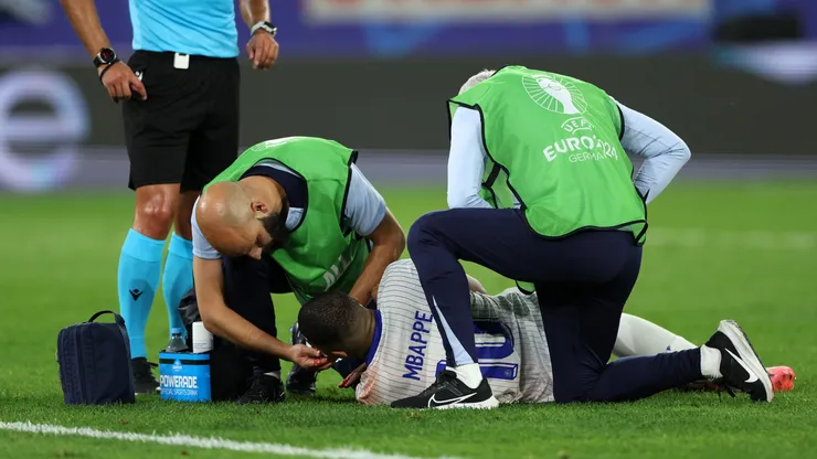 Kylian Mbappe of France receives medical treatment after clashing heads with Kevin Danso of Austria (not pictured) during the UEFA EURO 2024 group stage match between Austria and France at Düsseldorf Arena on June 17, 2024 in Dusseldorf, Germany.