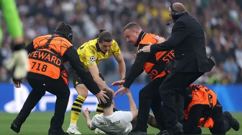 Marcel Sabitzer of Borussia Dortmund assists members of security as they stop a pitch invader during the UEFA Champions League 2023/24 Final match between Borussia Dortmund and Real Madrid CF at Wembley Stadium on June 01, 2024 in London, England.
