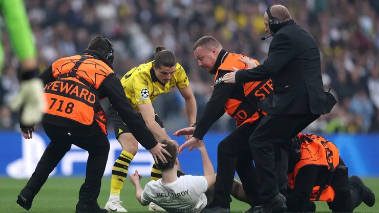 Marcel Sabitzer of Borussia Dortmund assists members of security as they stop a pitch invader during the UEFA Champions League 2023/24 Final match between Borussia Dortmund and Real Madrid CF at Wembley Stadium on June 01, 2024 in London, England.