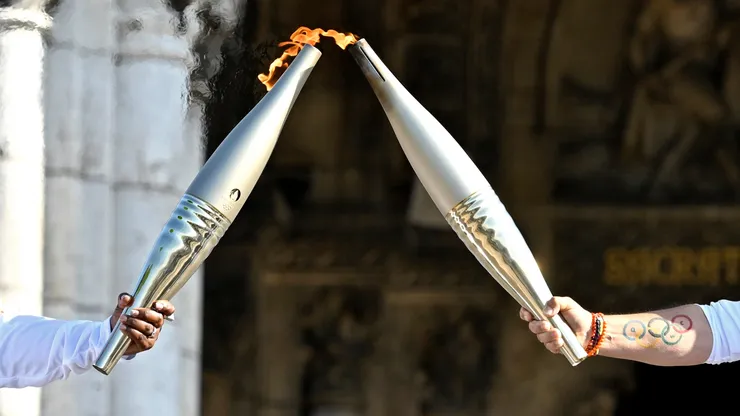 Claudia Tagbo, French-Ivorian actress and comedian and Pascal Touitou carry the Olympic Torch at Basilique du Sacre-Coeur de Montmartre during the second day of the Paris 2024 Olympic Torch Relay on July 15, 2024 in Paris, France.