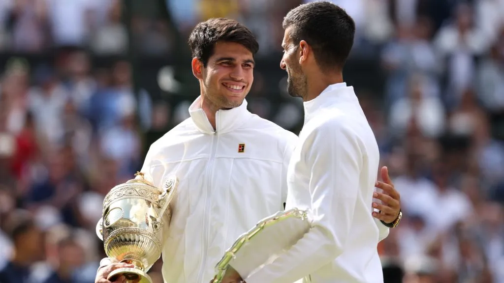 Carlos Alcaraz of Spain holds the Gentlemenās Singles Trophy while he talks to Novak Djokovic of Serbia as he holds his Runner-Up Trophy following the Gentlemenās Singles Final during day fourteen of The Championships Wimbledon 2024 at All England Lawn Tennis and Croquet Club on July 14, 2024 in London, England. Photo by Julian Finney/Getty Images