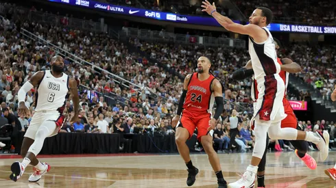 Stephen Curry #4 of the United States tosses an alley-oop pass to LeBron James #6 for a dunk ahead of Dillon Brooks #24 of Canada in the second half of their exhibition game ahead of the Paris Olympic Games.