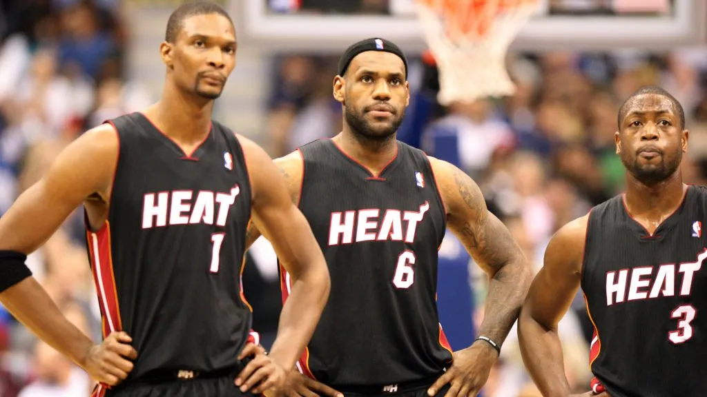 Chris Bosh #1, 2 #6 and Dwyane Wade #3 of the Miami Heat look on during their game against the Dallas Mavericks. Layne Murdoch/Getty Images