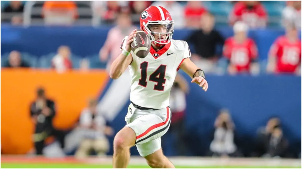 Georgia Bulldogs quarterback Gunner Stockton (14) rolls out looking for an open receiver during the second half of the Capital One Orange Bowl between the University of Georgia Bulldogs and the Florida State University Seminoles at Hard Rock Stadium in Miami Gardens, FL.