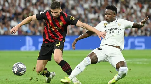 Ruben Dias of Manchester City is challenged by Vinicius Junior of Real Madrid