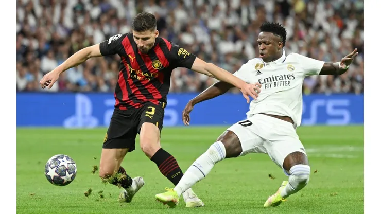 Ruben Dias of Manchester City is challenged by Vinicius Junior of Real Madrid