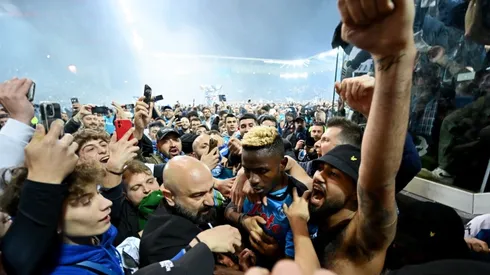 Victor Osimhen of SSC Napoli is surrounded by SSC Napoli fans who celebrate the Serie A title.