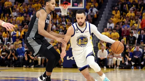 Stephen Curry #30 of the Golden State Warriors is guarded by Keegan Murray #13 of the Sacramento Kings