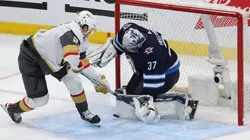 Connor Hellebuyck #37 of the Winnipeg Jets makes a save on Brett Howden #21 of the Vegas Golden Knights
