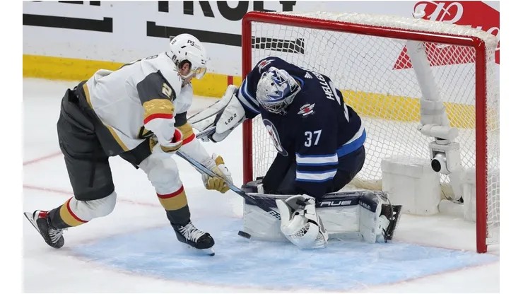 Connor Hellebuyck #37 of the Winnipeg Jets makes a save on Brett Howden #21 of the Vegas Golden Knights